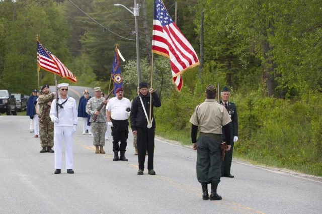 4G0A9309 American flags are carried through downtown Island Pond during the Memorial Day parade.