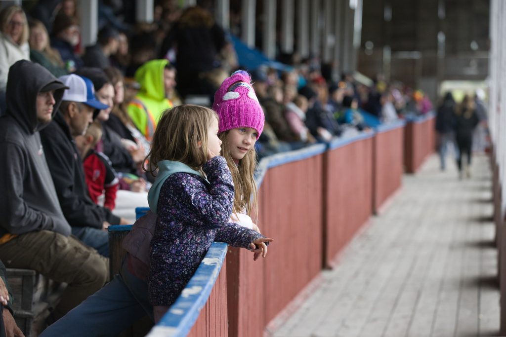 Two young girls watch the Memorial Day Demolition Derby from the grandstand at the Orleans County Fairgrounds in Barton, Vermont.