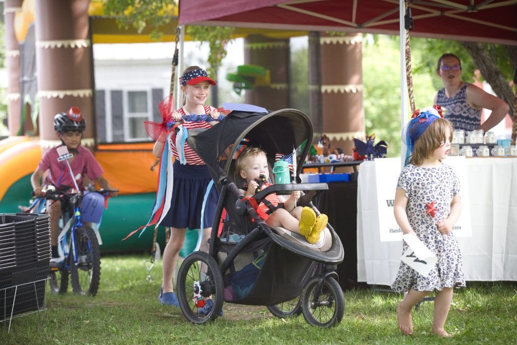 Children with patriotic decorations gather for the bicycle parade at the Danville Farmers Market’s Early Independence Day Celebration in Danville, Vermont.